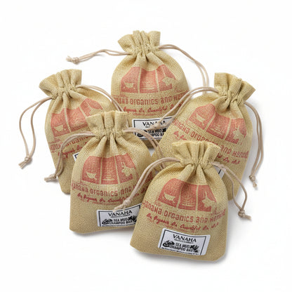 Three small drawstring pouches of Vanaha Sea Mud Shampoo Bar made from jute sacks with red printed text, arranged on a patterned red and cream rug.